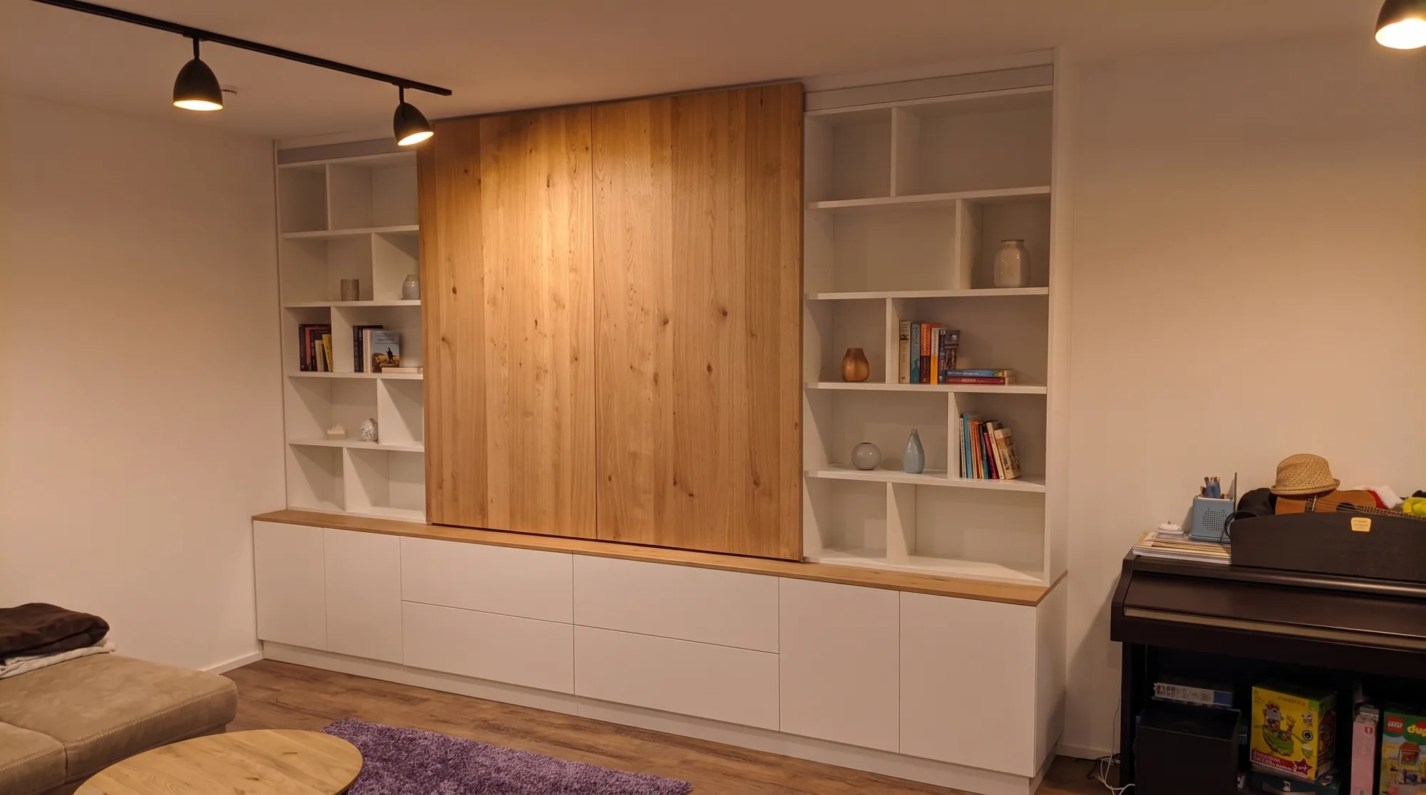 Wohnwand nach Maß mit Bücherregalen, weißem Sideboard und Eiche-Schiebetür